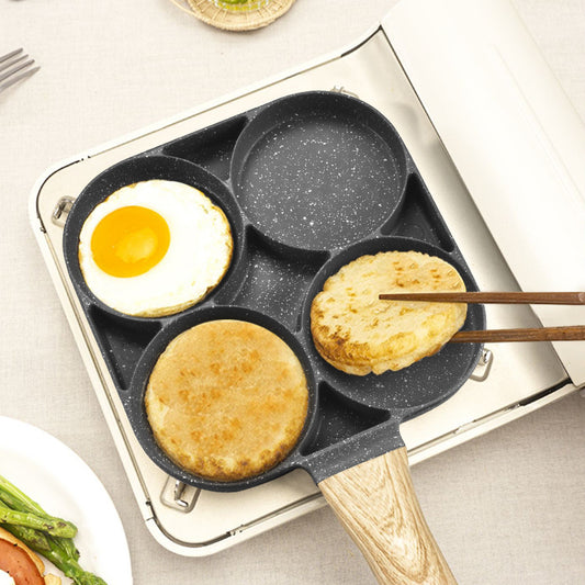 Multifunctional cooking pan with four compartments, each containing different food items, on a light surface.