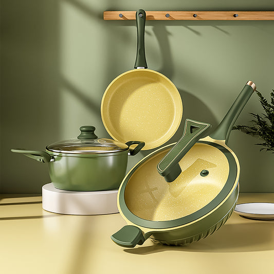 Set of green cookware including pots and pans on a wooden shelf with a green wall background.