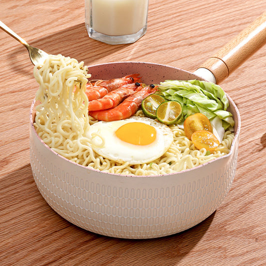 Noodle dish with egg, vegetables, and shrimp in a bowl on a wooden table.